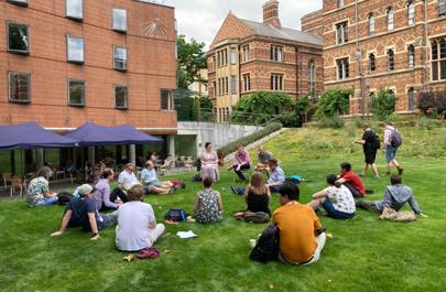 Attendees of the Digital Humanities Summer School listen to a panel discussion on the grass of Keble College