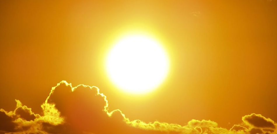 Photograph of orange sun and sky above clouds