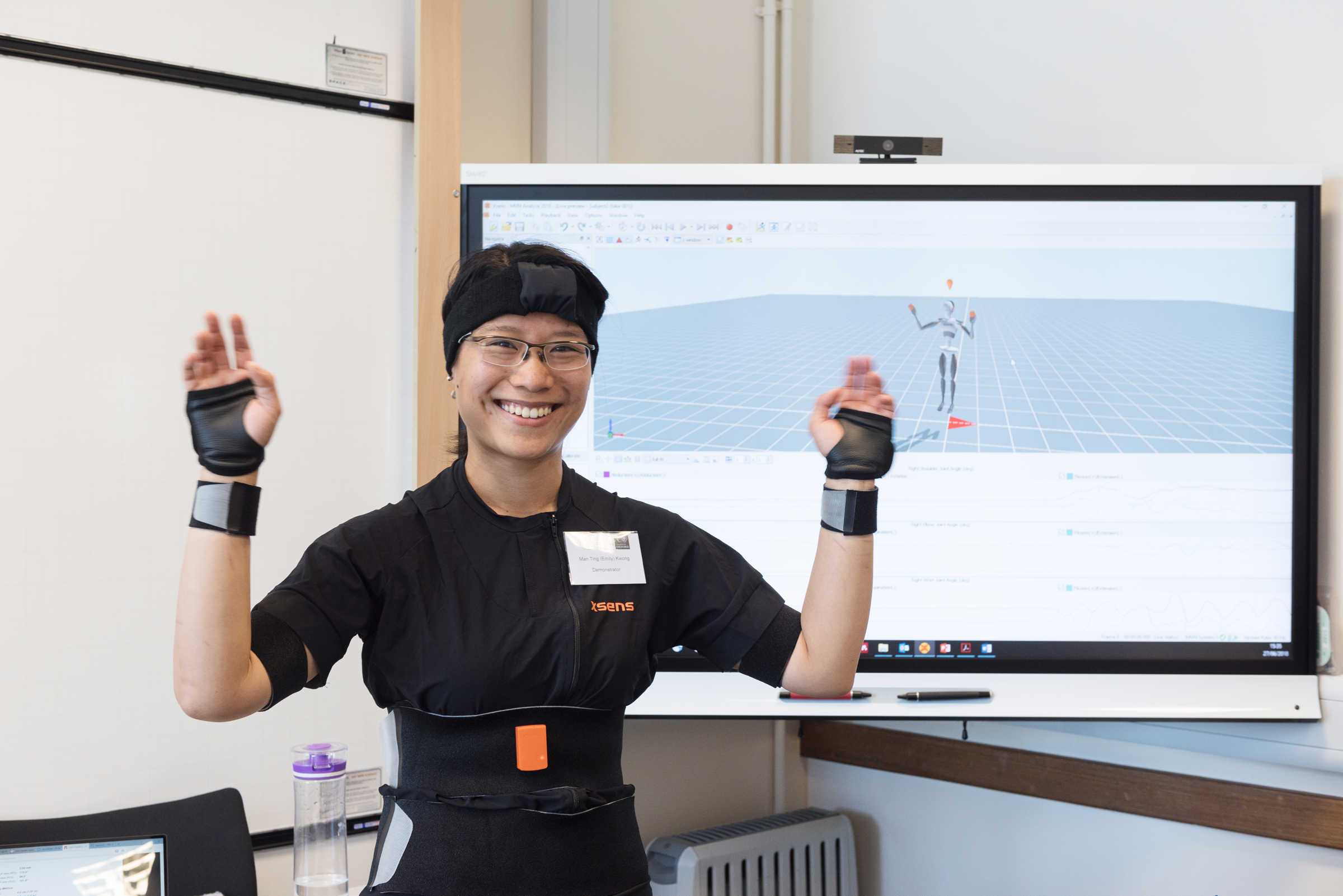 Person wearing motion sensor equipment and smiling